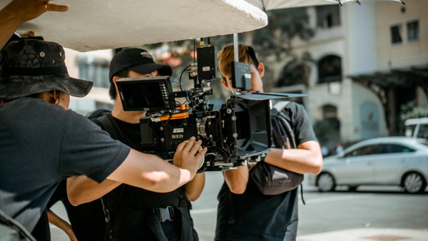 A camera crew preparing a cinema camera for an outdoor scene